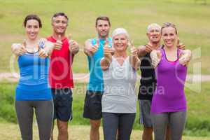 Happy athletic group smiling at camera with thumbs up