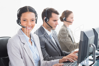 Business people with headsets using computers