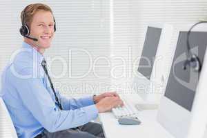 Handsome agent with headset typing on keyboard