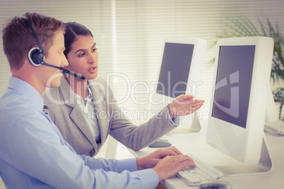 Business team working on computers and wearing headsets