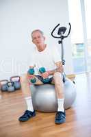 Old man sitting on exercise ball