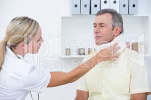 Doctor examining patient wearing neck brace