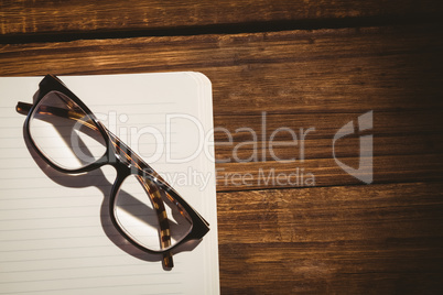 Empty notepad with reading glasses