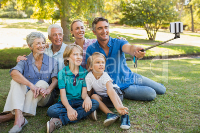 Happy family using a selfie stick in the park