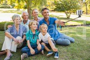 Happy family using a selfie stick in the park