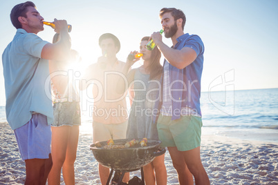 Happy friends doing barbecue and drinking beer