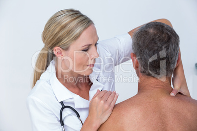 Doctor examining her patient shoulder