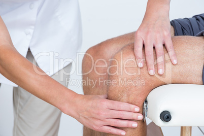 Doctor examining her patient knee