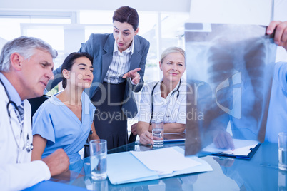 Team of doctors and businesswoman examining xray