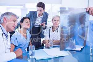 Team of doctors and businesswoman examining xray