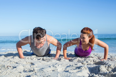 Happy couple doing push ups together