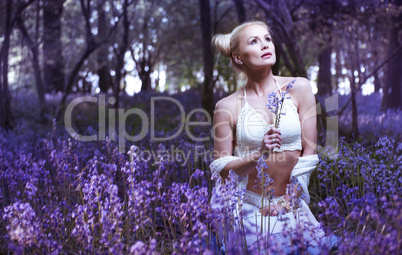 Artistic portrait of a girl in a bluebell forest