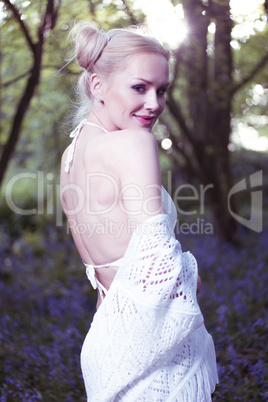 Artistic portrait of a girl in a bluebell forest