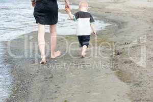 Mother and child walking along the beach
