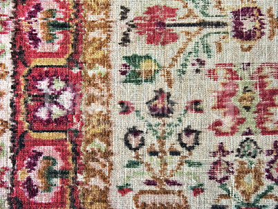 old faded carpet with floral ornament closeup