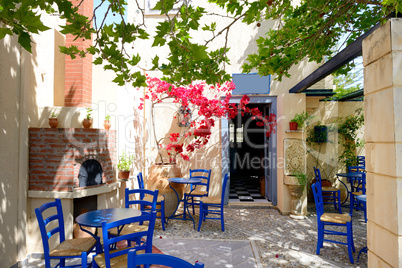 The amphora with flowers and traditional Greek table and chairs