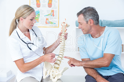 Doctor showing her patient a spine model