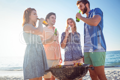 Happy friends doing barbecue and drinking beer