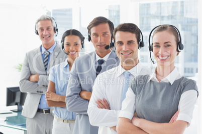 Business people with headsets smiling at camera