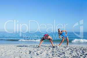 Happy couple stretching together beside the water