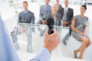 Businessman talking in microphone during conference