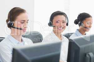 Business people with headsets smiling at camera