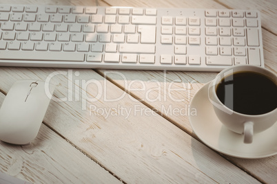 White keyboard and cup of coffee