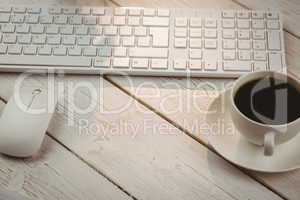 White keyboard and cup of coffee