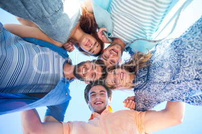 Happy friends standing in circle and looking at camera