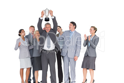 Excited business team cheering at camera with trophy