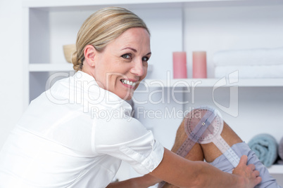 Doctor examining man leg with tool