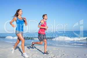 Happy couple running together beside the water