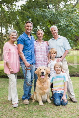 Happy family smiling at the camera with their dog