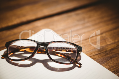 Empty notepad with reading glasses