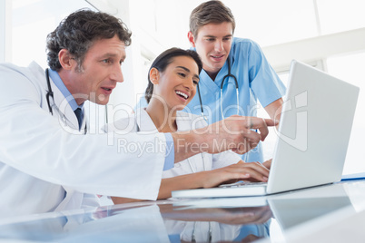 Team of happy doctors working on laptop computer