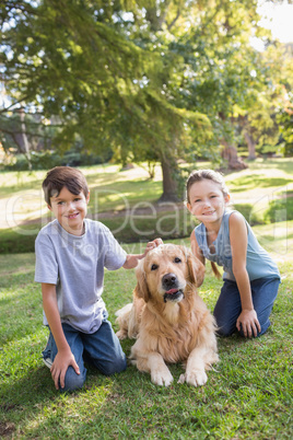 Sibling with their dog in the park