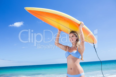 Pretty blonde woman holding surf board