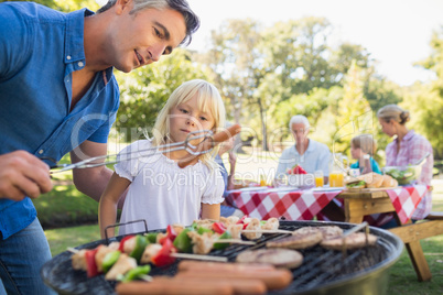 Happy father doing barbecue with her daughter