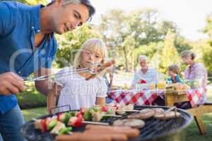 Happy father doing barbecue with her daughter