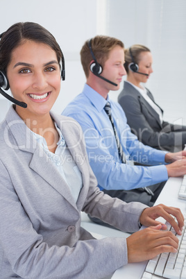 Business team working on computers and wearing headsets Business team working on computers and wearing headsets