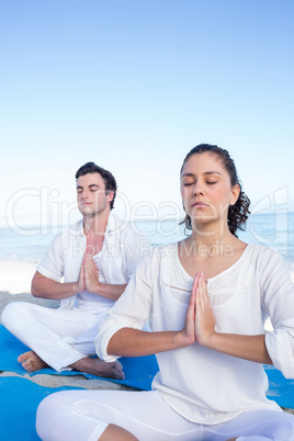 Happy couple doing yoga beside the water Happy couple doing yoga beside the water