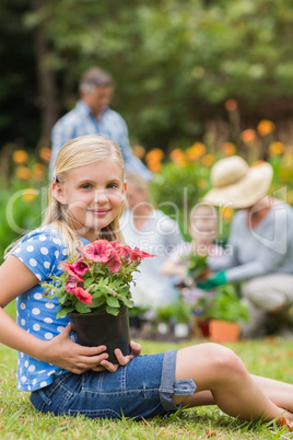 Young girl sitting with flower pot