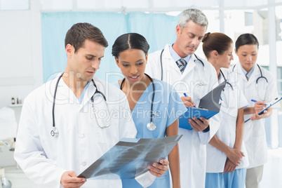 Male and female doctors examining x-ray