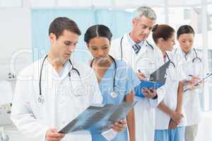 Male and female doctors examining x-ray