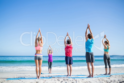 Friends doing yoga together with their teacher