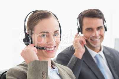 Business people with headsets smiling at camera