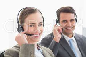 Business people with headsets smiling at camera