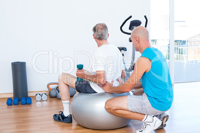 old man having back massage on exercise ball