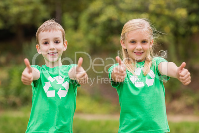 Happy siblings in green with thumbs up