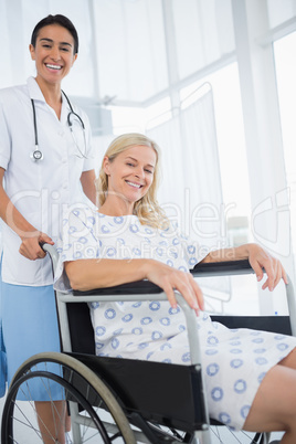 Doctor and patient in wheelchair smiling at camera